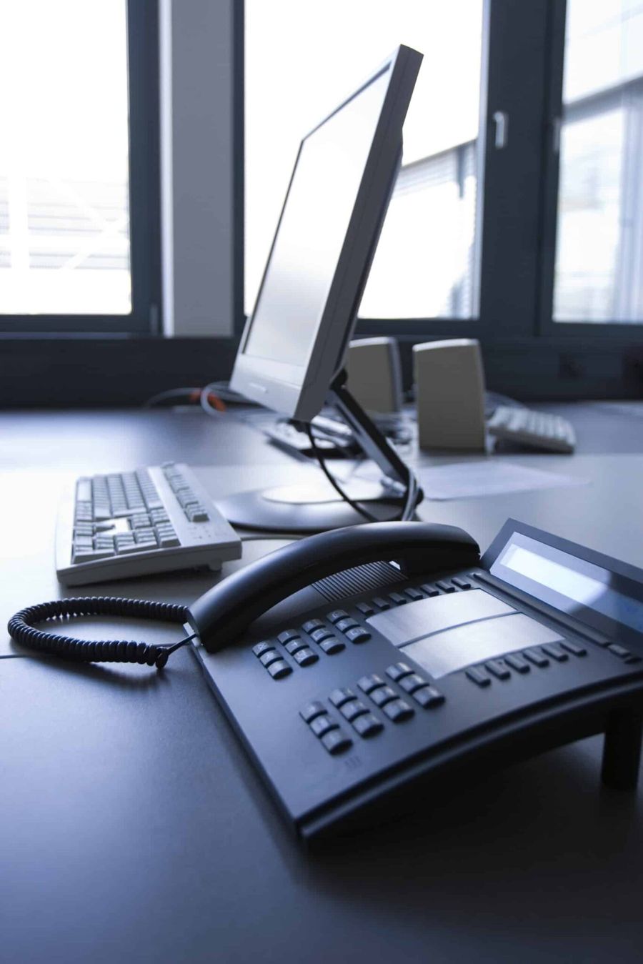 Office desk with a business phone and computer